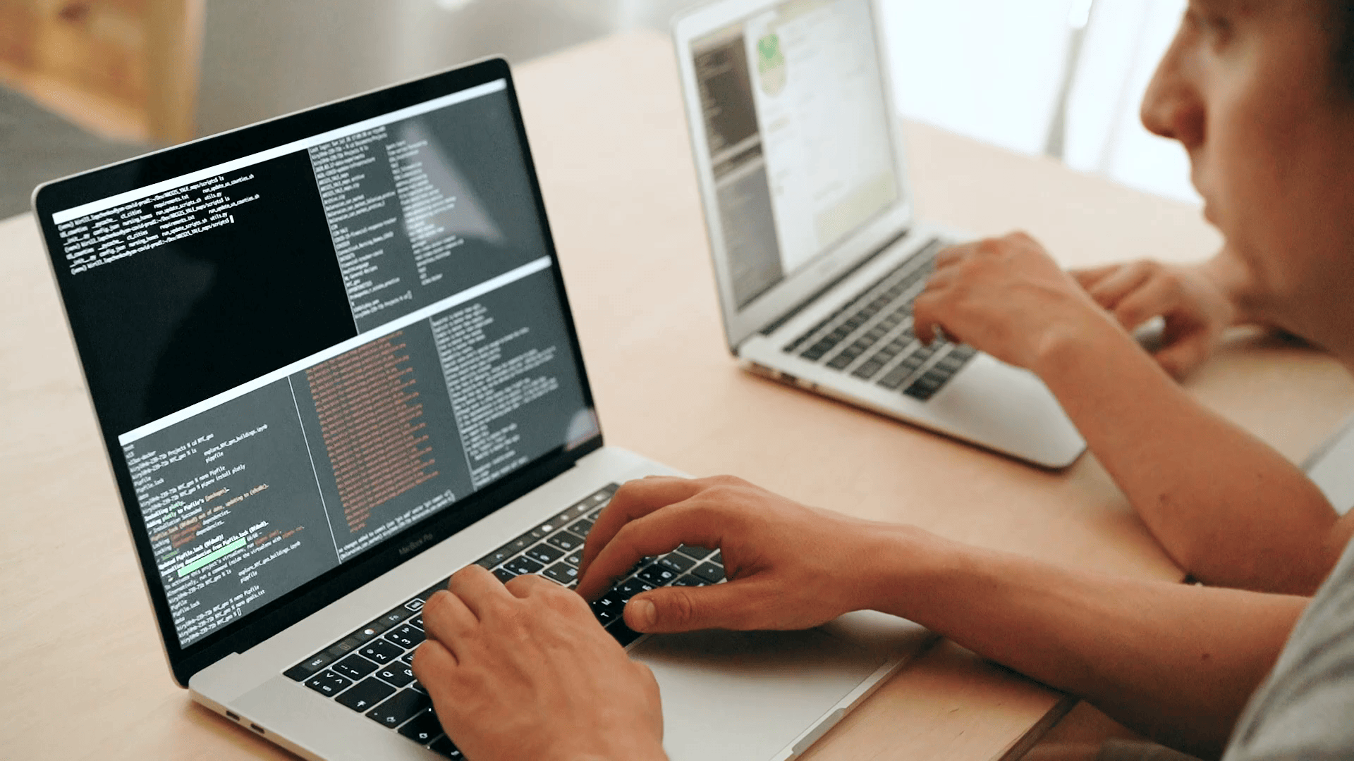 A developer writing code on a laptop
